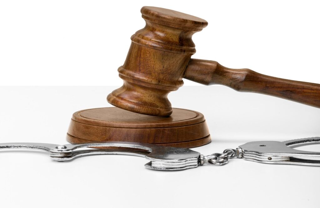 Sanz Bremond Abogados, abogados especialistas en derecho civil y sucesiones en Castellón de la Plana. Mallete en frente de unas esposas.