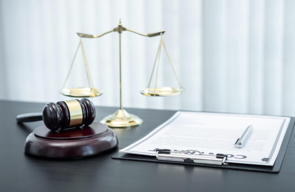 Sanz Bremond Abogados, asesoría legal integral en derecho penal y administrativo en Almassora. Mallete junto a un contrato.