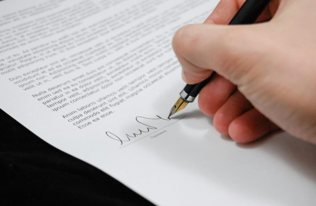 Sanz Bremond Abogados, asesoría legal integral en derecho penal y administrativo en Borriol. Persona firmando unos papeles,