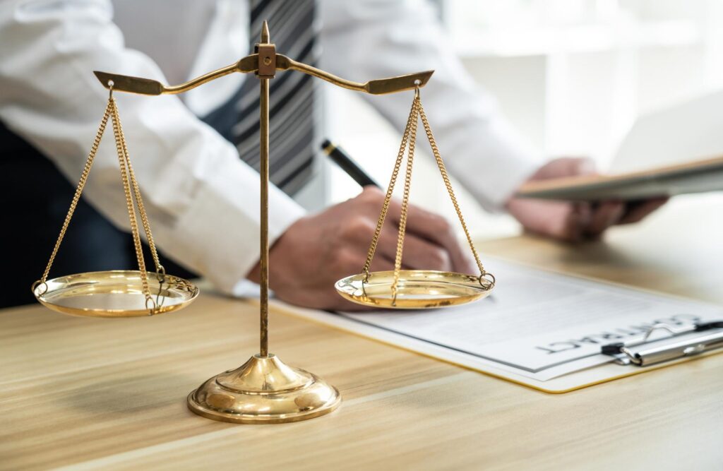 Sanz Bremond Abogados, asesoría legal integral en derecho penal y administrativo en Burriana. Persona firmando papeles detrás de una bascula.