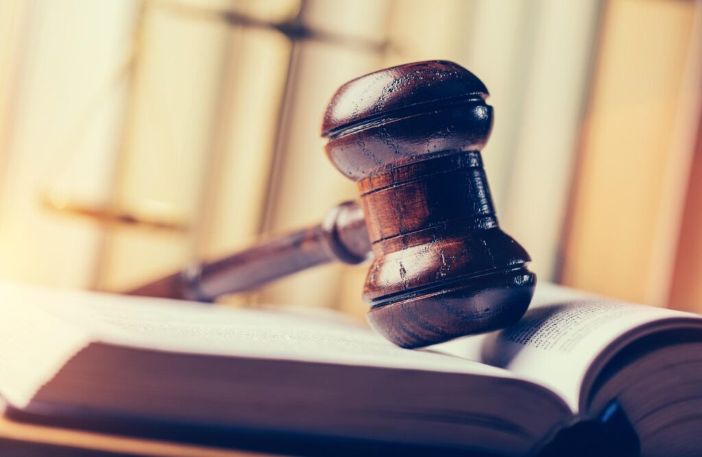 Sanz Bremond Abogados, asesoría legal integral en derecho penal y administrativo en Moncofa. Mallete sobre un libro abierto.