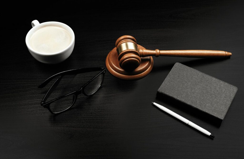 Sanz Bremond Abogados, asesoría legal integral en derecho penal y administrativo en Nules. Mallete marrón alrededor de cosas negras.